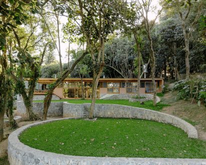 Curving stone walls around rectilinear Brazilian home