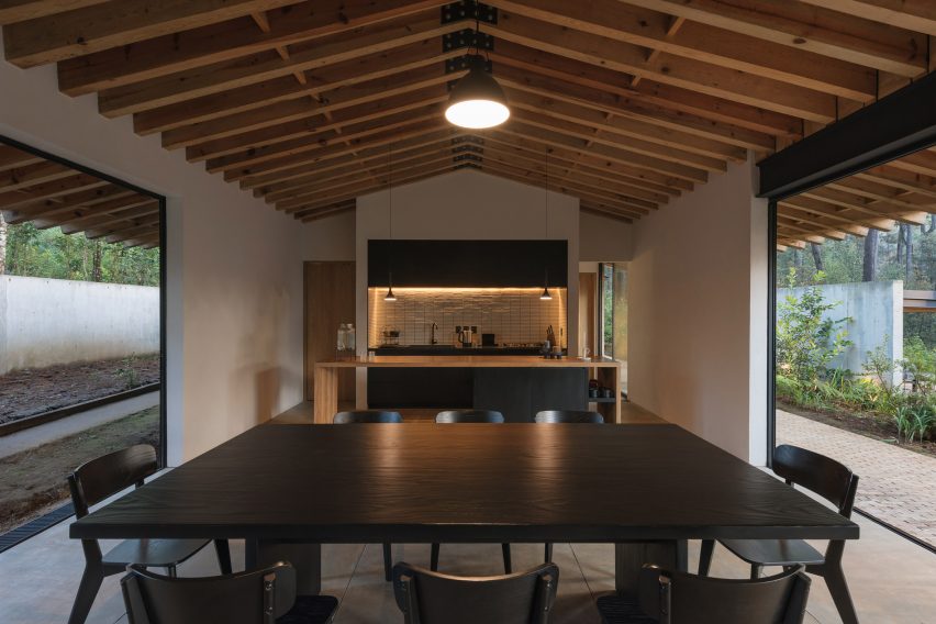 Open-plan kitchen and dining room with a black wooden table and kitchen island