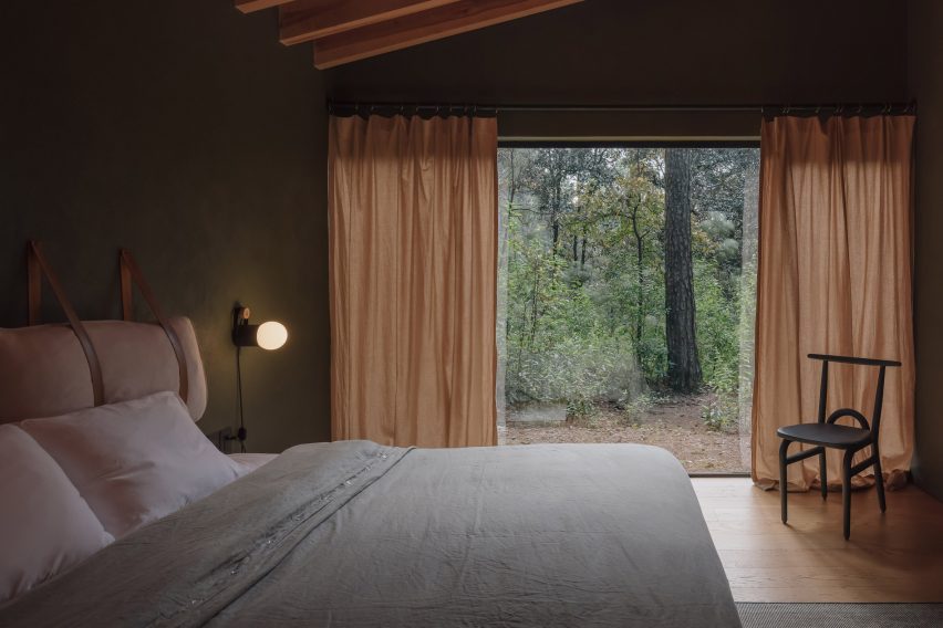 Bedroom with dark timber walls and sheer linen curtains