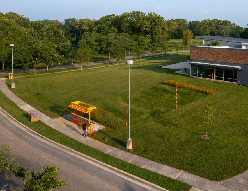 A patch of long grass with a brightly colored observation deck for Exhibit Columbus