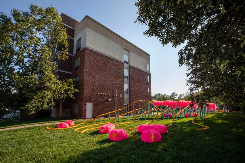 An installation with undulating plastic tubing held up by blue poles