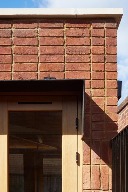 Close up of red handmade bricks and oak doors