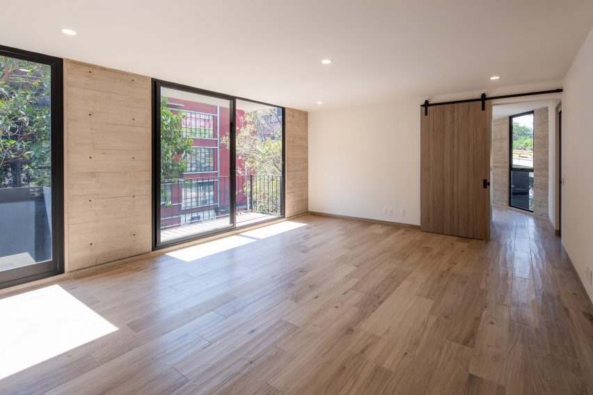 Interior space with white walls, wood flooring and glass sliding double doors