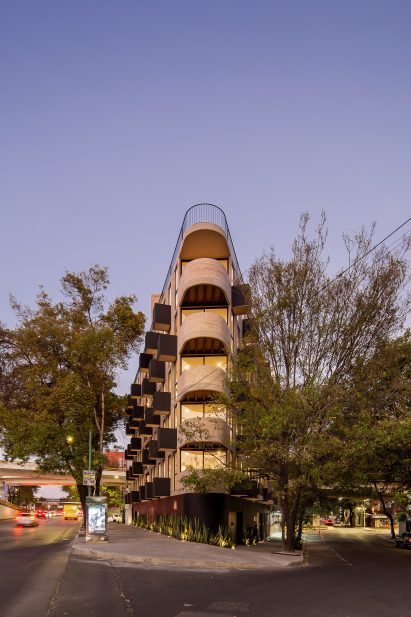 Triangular concrete building with rounded corner by HGR Arquitectos