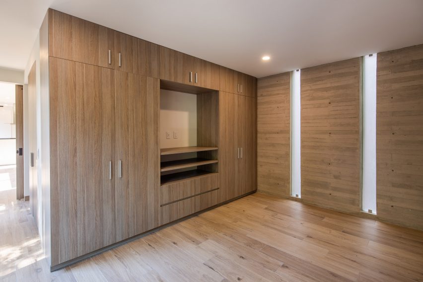 Room with timber flooring and built-in wooden wall storage