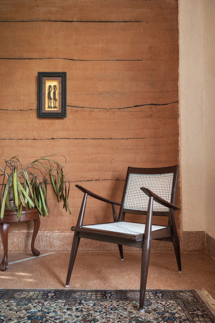 Chair in front of rammed earth wall in Hybrid House by Sketch Design Studio