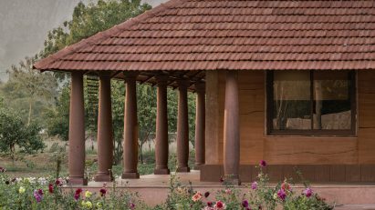 Veranda with tiled roof and sandstone columns at Hybrid House by Sketch Design Studio