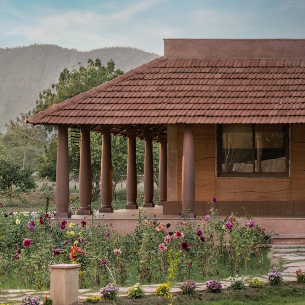 Veranda with tiled roof and sandstone columns at Hybrid House by Sketch Design Studio