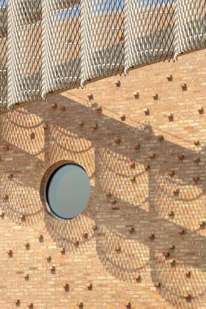 Brick wall with extruded bricks and perforated aluminium screens