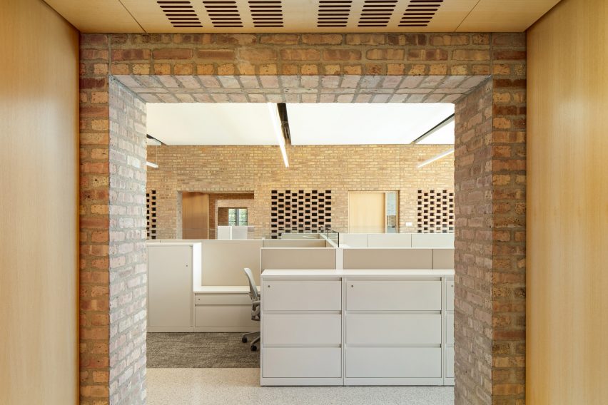 Opening in a brick wall revealing an office space