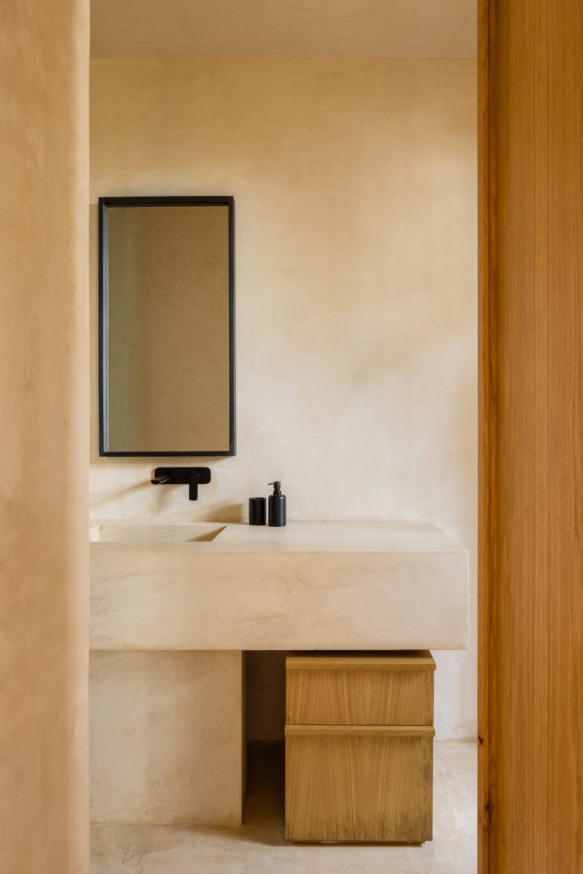 A bathroom with light walls and a mirror with a black frame