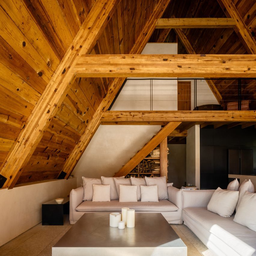 A living room in an A-Frame with white couches