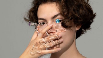 Person holding a piece of glass jewellery in front of their face
