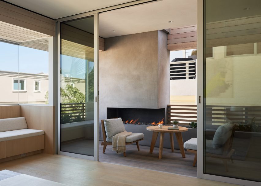 Outdoor balcony with sliding glass doors leading to a lounge space