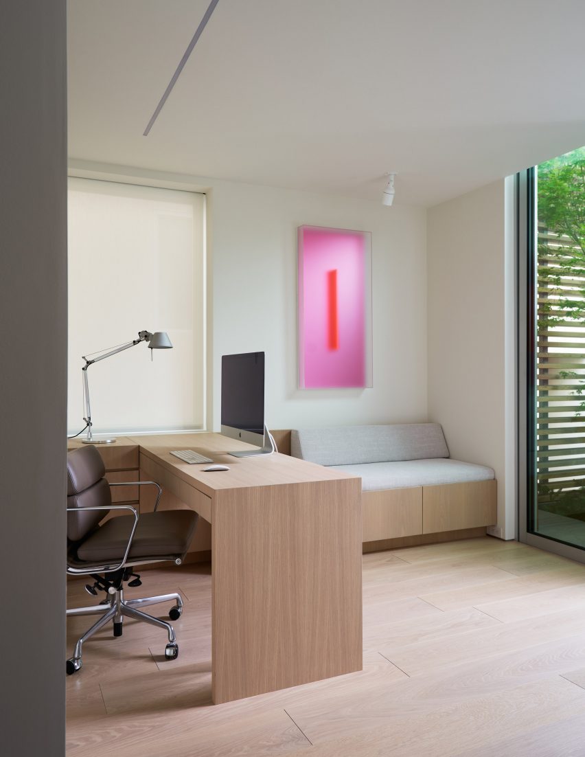 Study with wood flooring, timber desk and a grey swivel chair