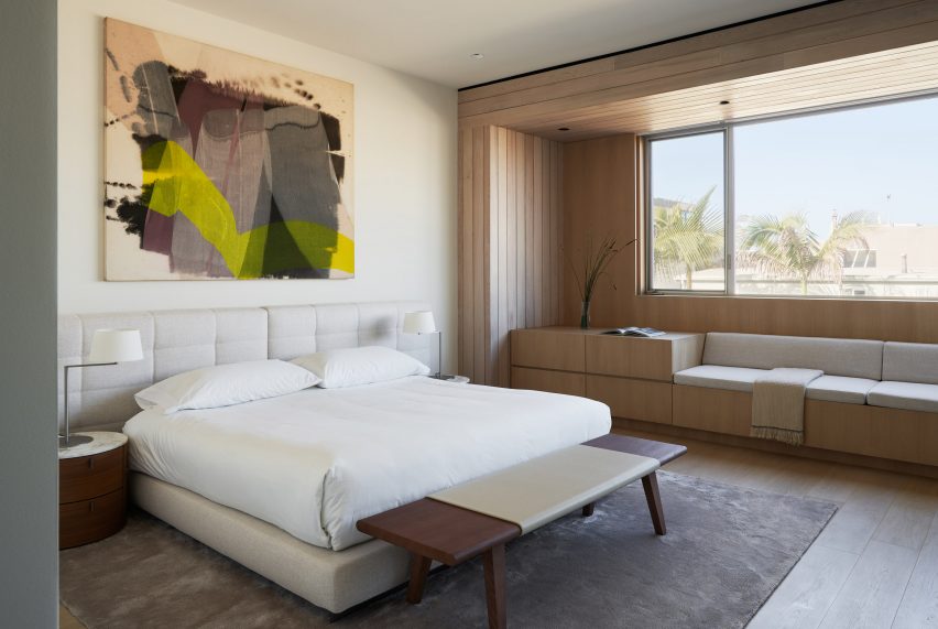 Bedroom interior with a white bed and seating below a window