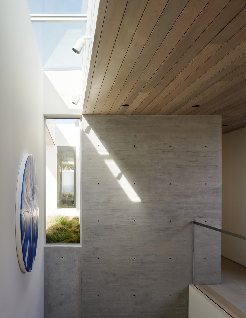 Top of a staircase with wood-line ceilings, stone walls and a skylight