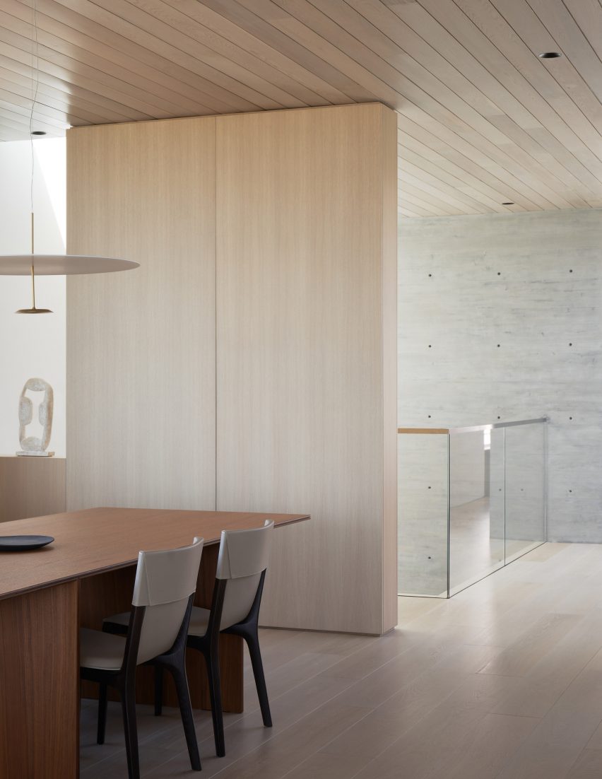 Dining room with wood floors and ceiling, a wooden table and a pendant light