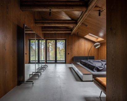 Bed in wood-panelled bedroom with retro lighting