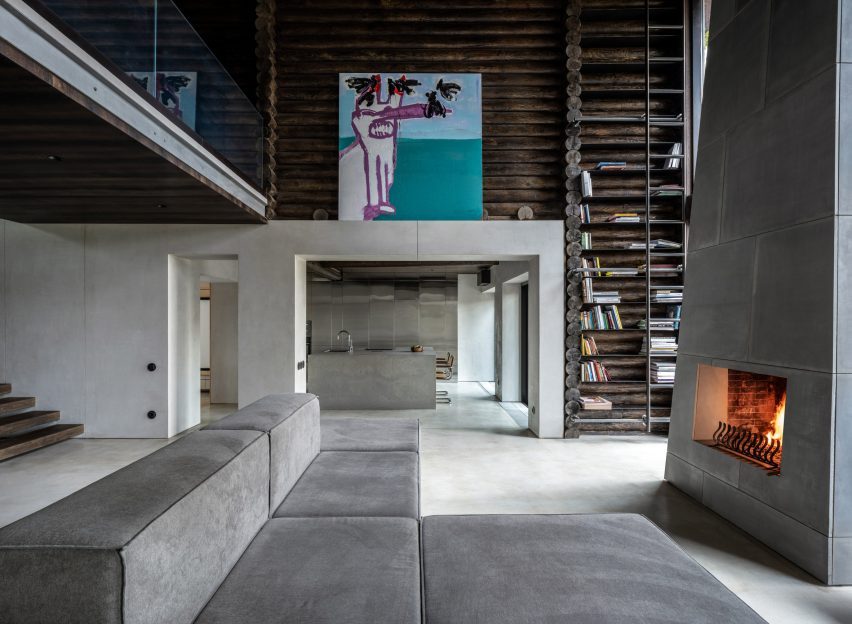 Photograph showing large sofa in living area looking into kitchen