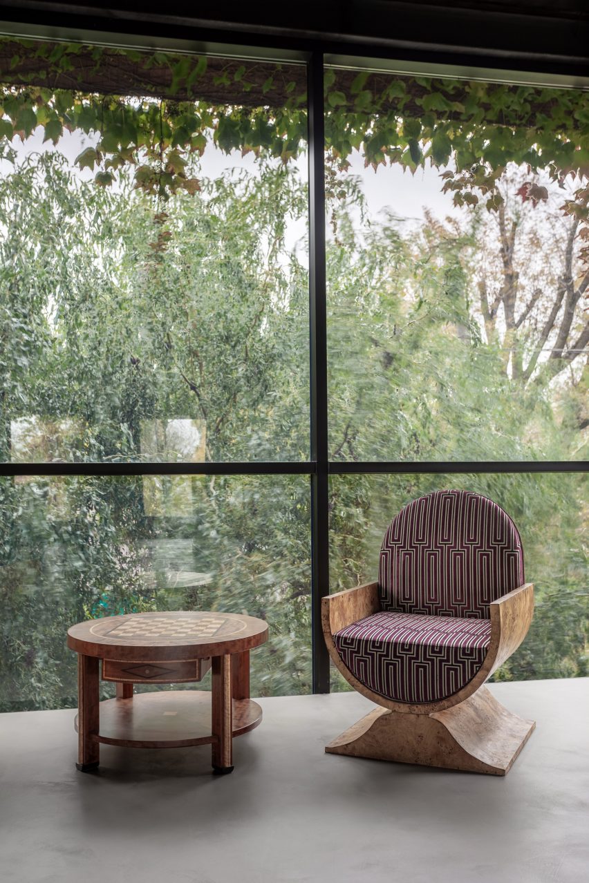 Photograph of wooden chair and table in front of big window