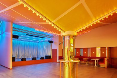 Mirrored column supporting angled ceiling with carnival lights