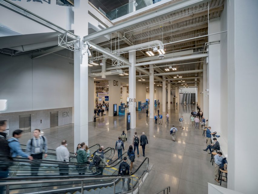 An escalator descending into basement level exhibition hall