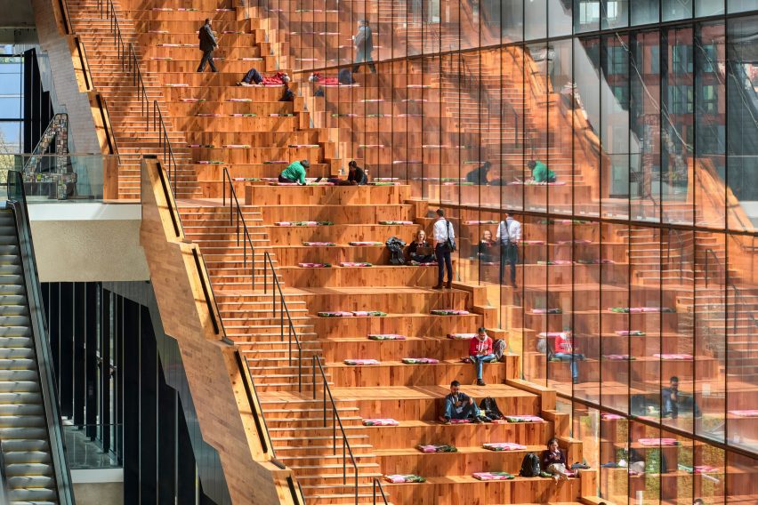 People sitting on a large wooden staircase