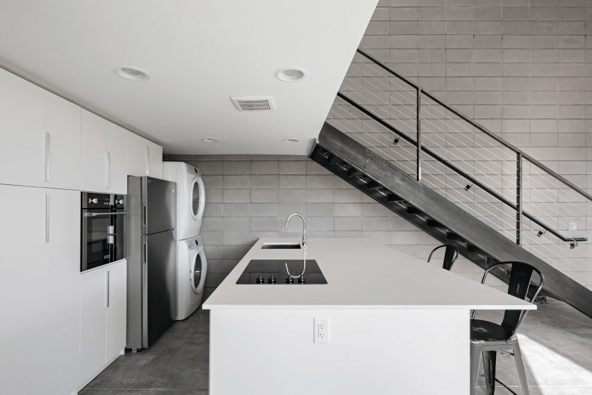 White kitchen with an island and mezzanine above