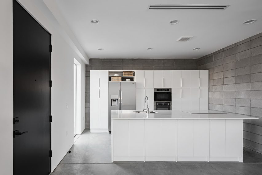 Kitchen with a white island and concrete block walls