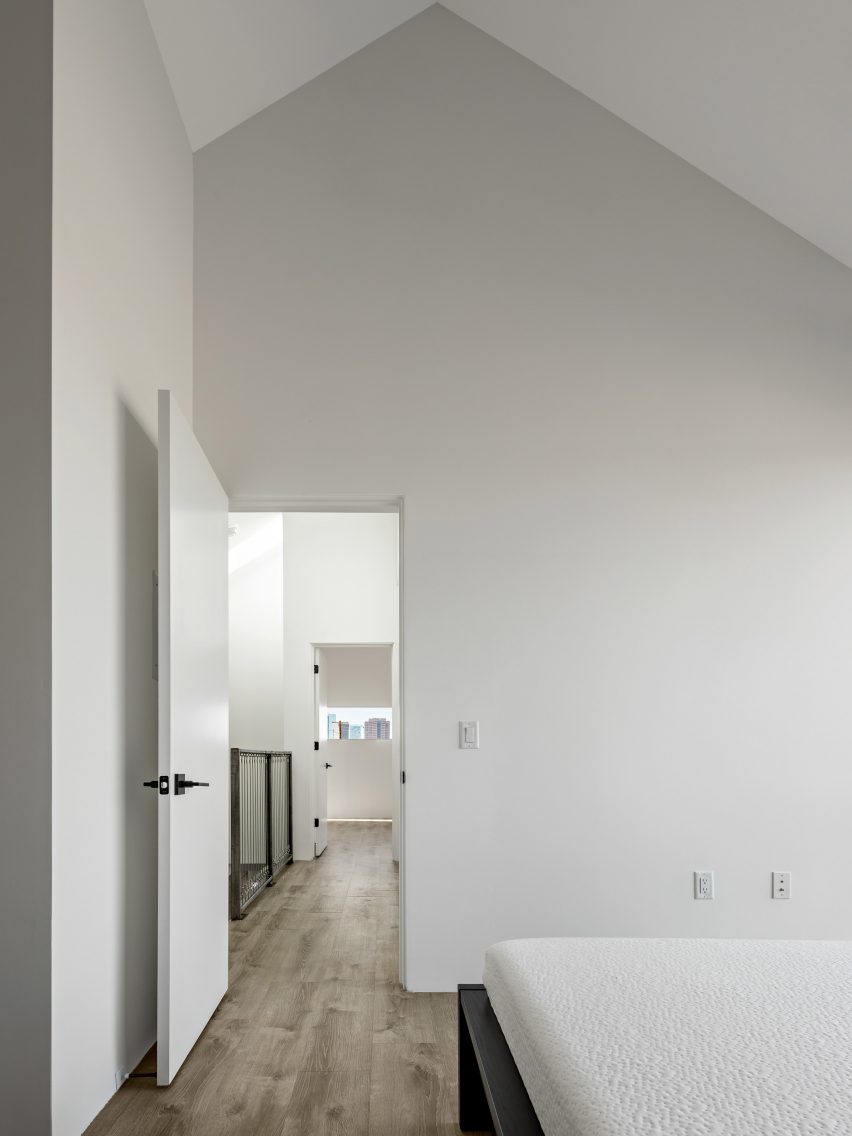 White room with a pitched roof and wood flooring