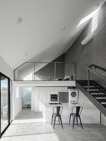 Double-height space with a sloping roof and steel staircase