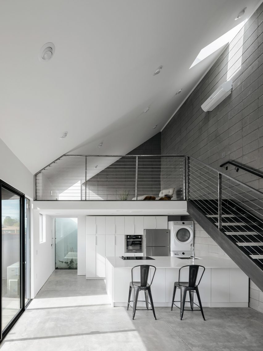 Double-height space with a sloping roof and steel staircase