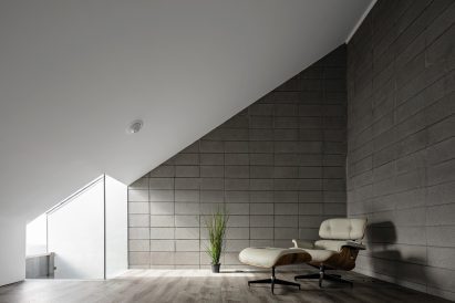 Room with a sloped roof and lounge chair