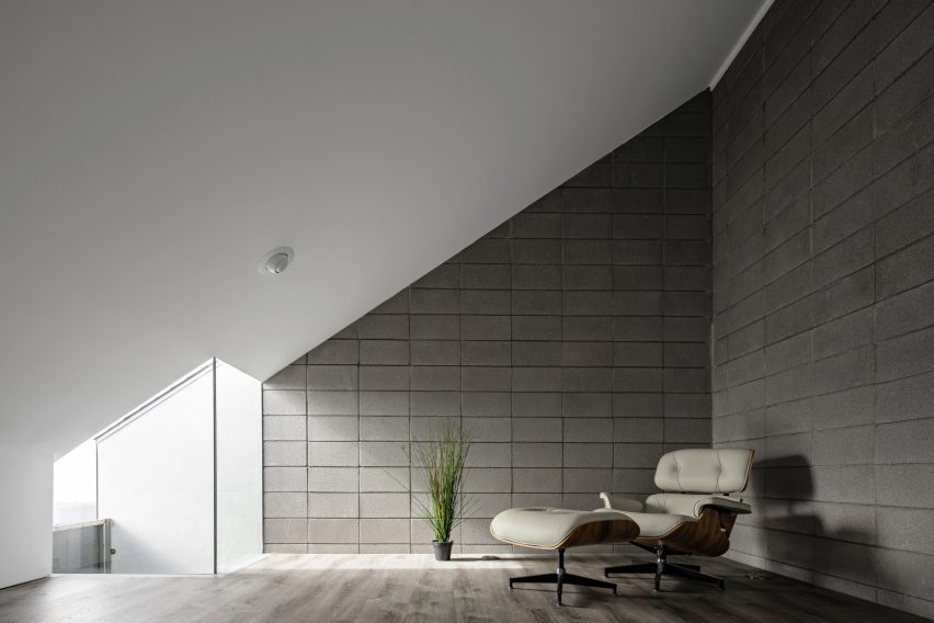 Room with a sloped roof and lounge chair