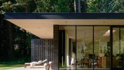 Exterior of a one-storey house on a concrete plinth by GO'C