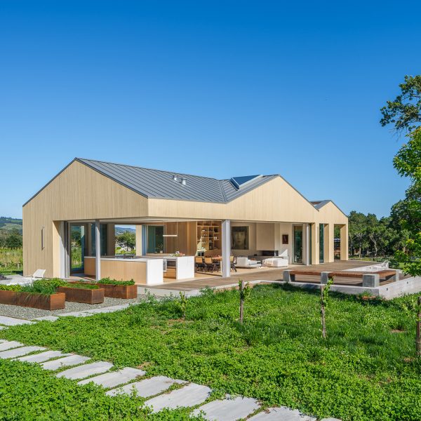 Timber barn with wrap-around open doors with green garden