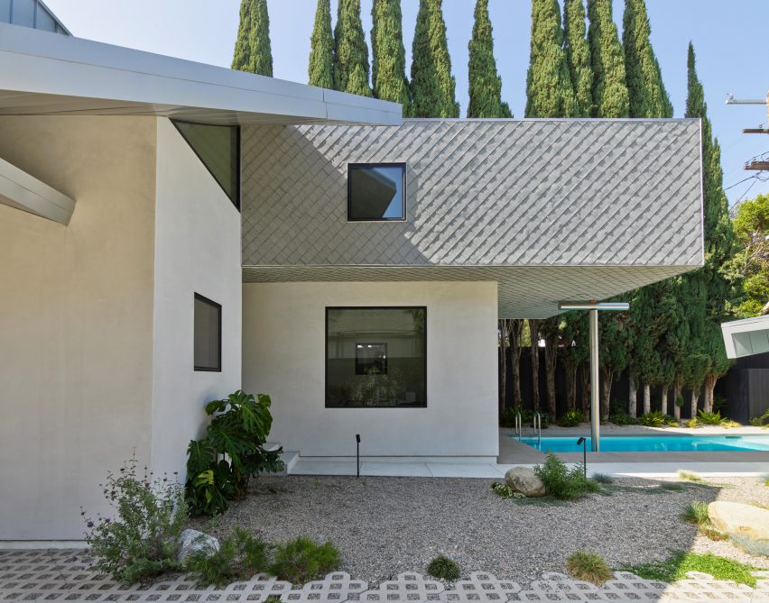 Cantilevered second storey house extension over an outdoor swimming pool