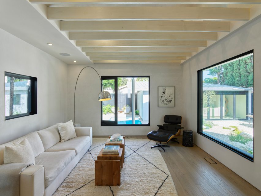 Living room interior with exposed roof beams and white sofa