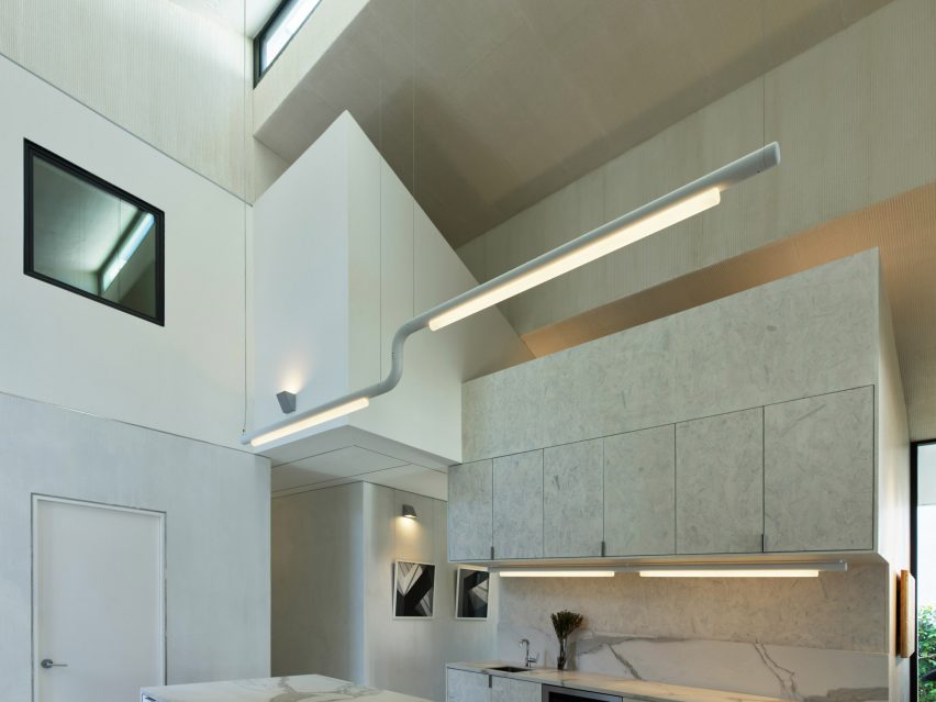 Double-height space with a faceted roof and hanging strip lights