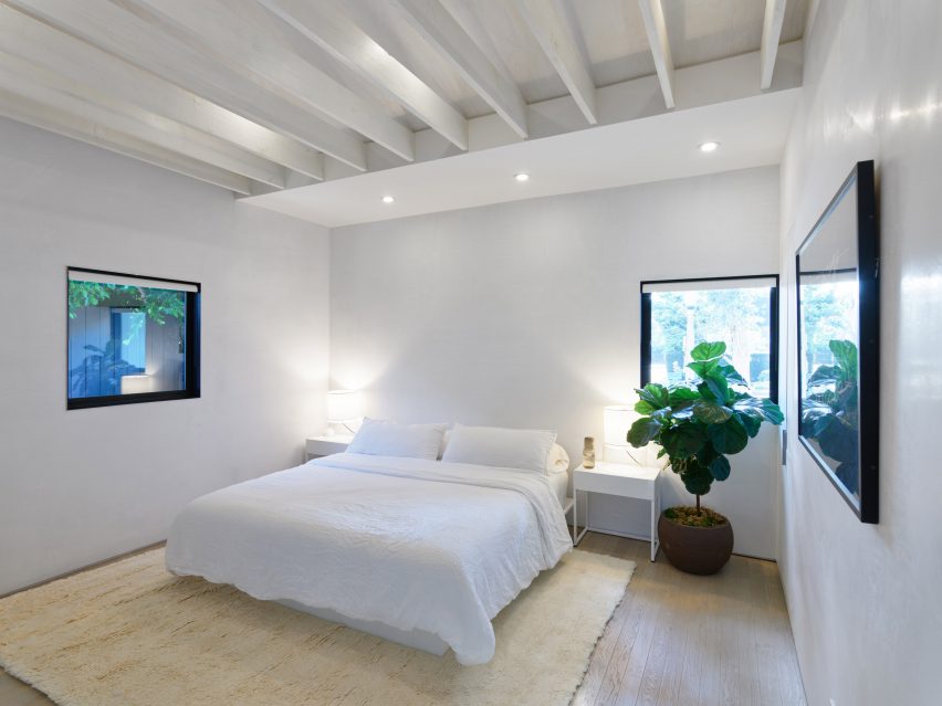 White bedroom with exposed roof beams