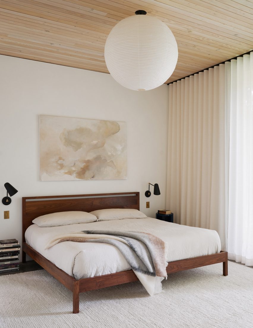 Bedroom with white walls, timber ceiling and dark timber bed frame