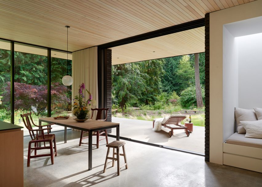 Dining room with floor-to-ceiling windows and a wooden table and chairs