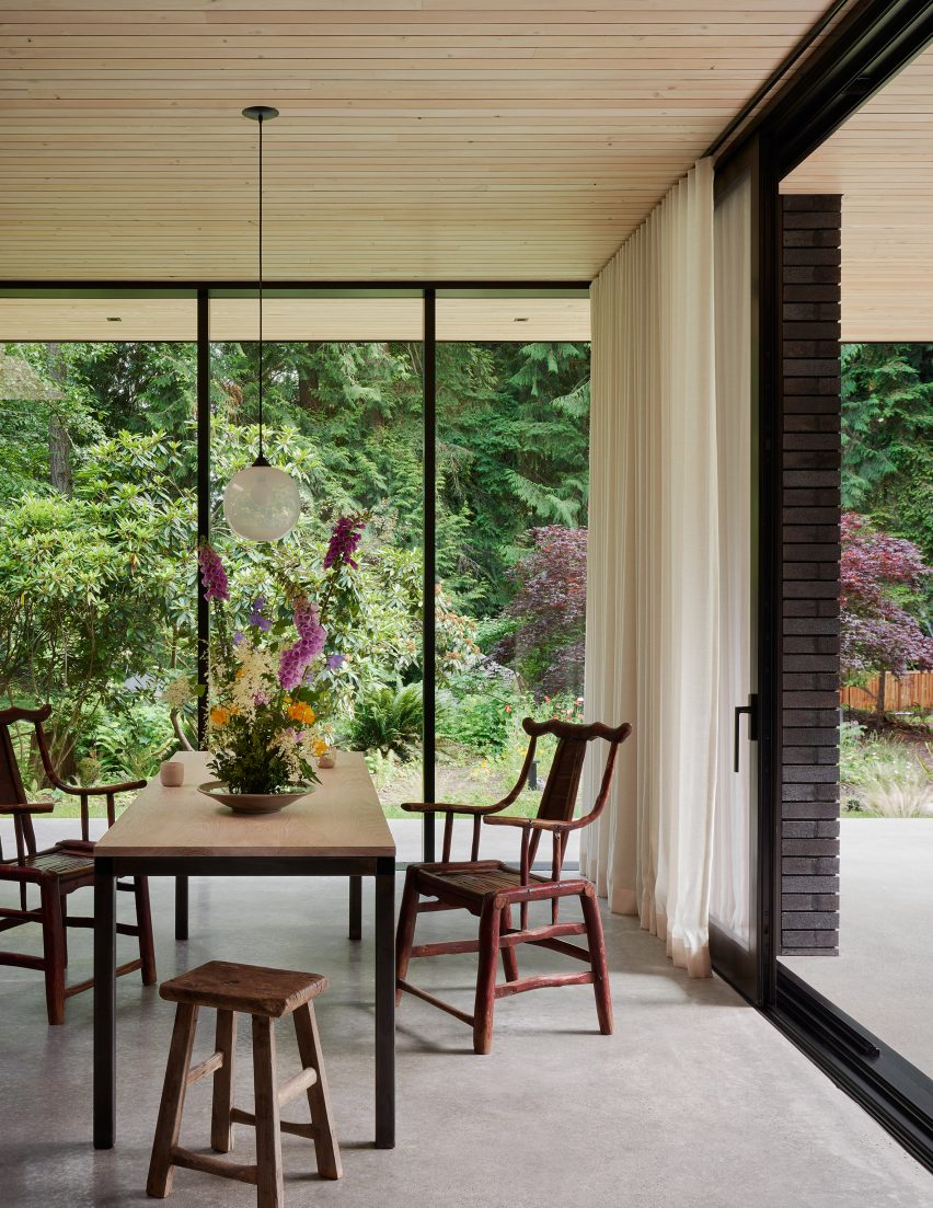Dining room with floor-to-ceiling windows and a wooden table and chairs