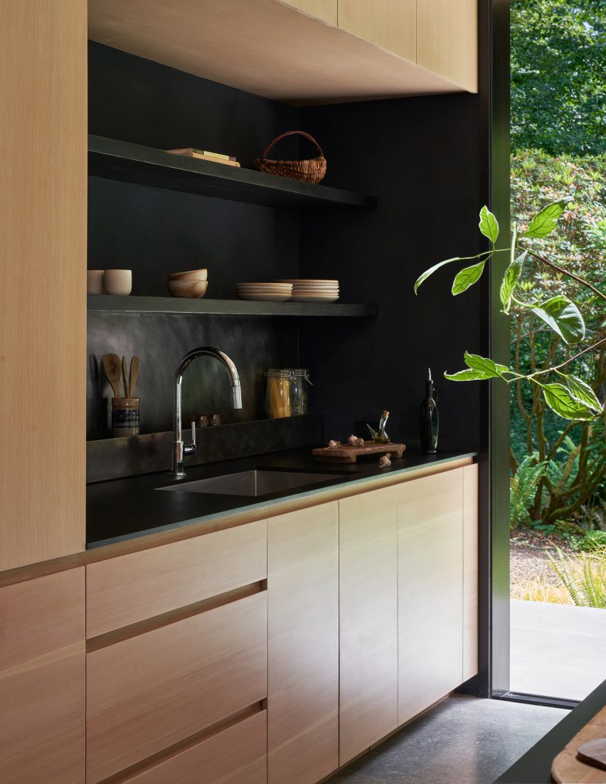 Kitchen with wooden units and black shelving and worktops