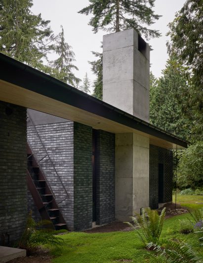 Black brick and concrete exterior of a home by GO'C