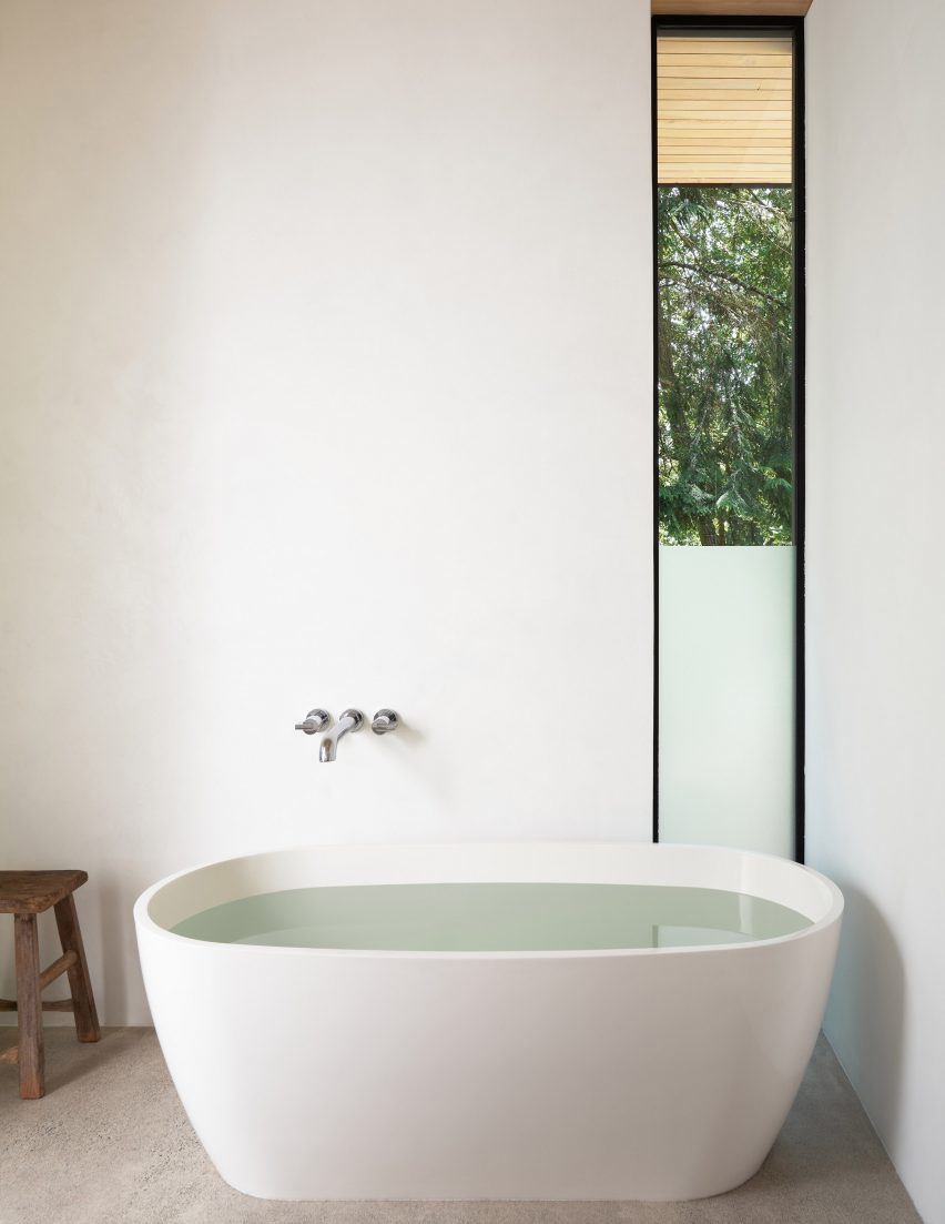 White oval bath with silver wall-mounted taps
