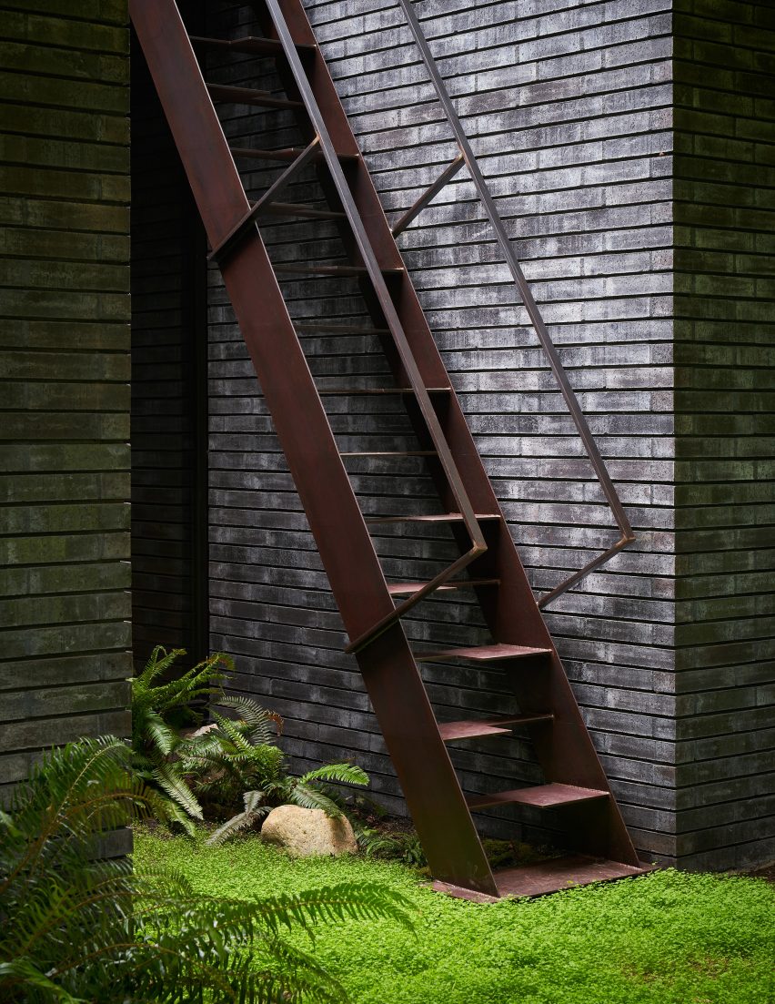 Metal staircase next to a black brick wall