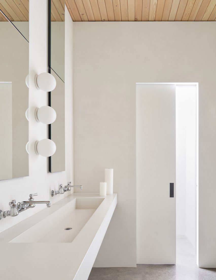 White bathroom with a double sink and timber ceiling