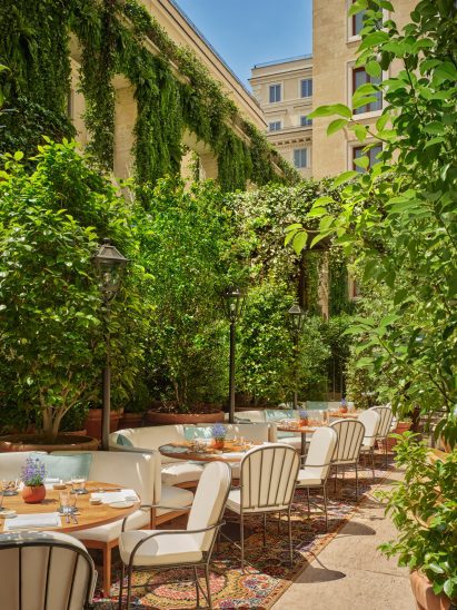 Sunken plant-filled courtyard with teak banquettes and furniture